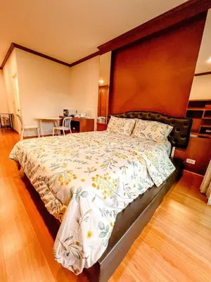 a bedroom with a large bed with a wooden headboard at Green Place in Phuket Town