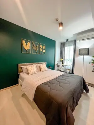 a bedroom with a large bed with a green wall at Central Pool in Ban Lo Long