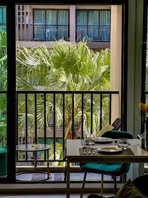 a restaurant with two tables and a view of a palm tree at Central Pool in Ban Lo Long