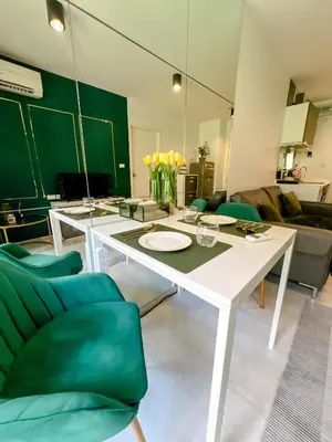a living room with a white table and green chairs at Central Pool in Ban Lo Long