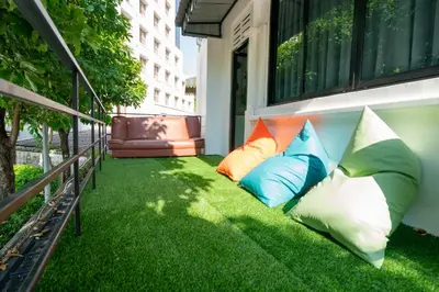 a balcony with colorful pillows on the grass at Phunaya Phuket Oldtown Hotel in Phuket Town