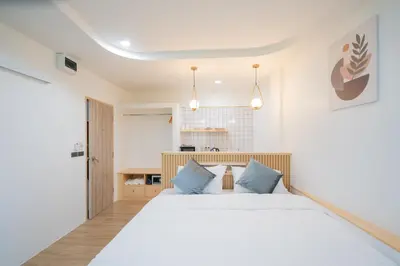a bedroom with a large white bed with blue pillows at Phunaya Phuket Oldtown Hotel in Phuket Town