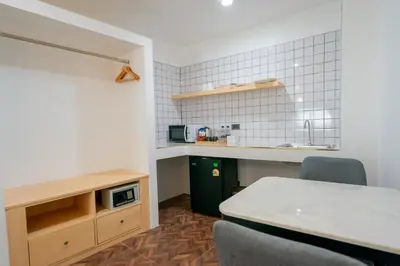 a kitchen with a table and chairs in a room at Phunaya Phuket Oldtown Hotel in Phuket Town