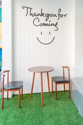 two chairs and a table with a sign that reads thank you for counting at Phunaya Phuket Oldtown Hotel in Phuket Town