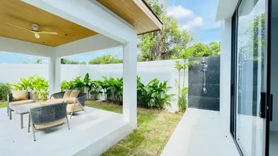 an outdoor patio with a table and chairs at Mouana Residence Song Khun Chalong 8910 in Phuket Town
