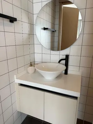 a bathroom with a white sink and a mirror at Fantasea Condo Kamala in Kamala Beach