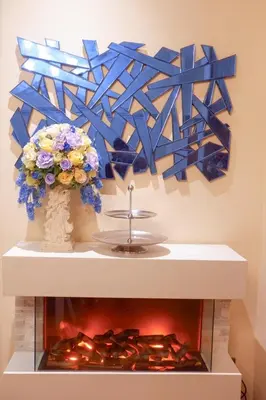 a fireplace with a blue painting and flowers on a wall at Rare Sunrise Cliff Villa 5 Bedrooms in Ban Lo Ti Pa (1)