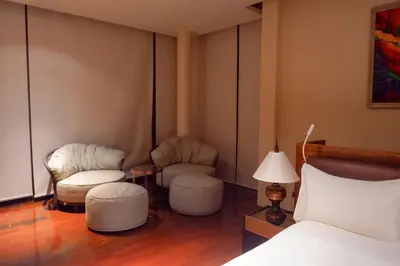 a bedroom with two chairs and a bed and a lamp at Rare Sunrise Cliff Villa 5 Bedrooms in Ban Lo Ti Pa (1)