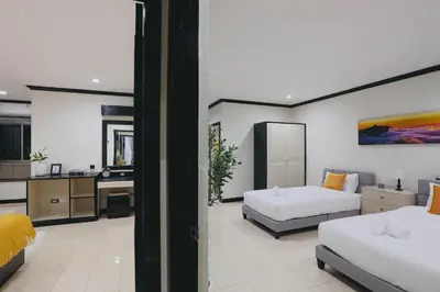 a living room with two beds and a kitchen at Wink City 4 Patong Phuket in Patong Beach