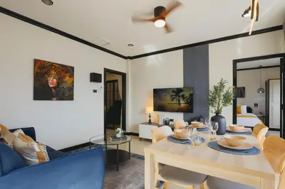a living room with a table and a blue couch at Wink City 4 Patong Phuket in Patong Beach