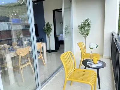 a balcony with yellow chairs and a table and a table at Wink City 4 Patong Phuket in Patong Beach