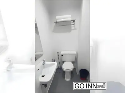 a white bathroom with a toilet and a sink at XX GO INN Patong Beach in Patong Beach