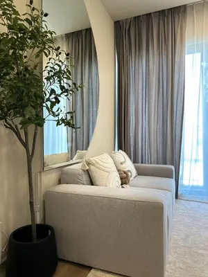 a living room with a couch and a potted tree at DLUX 7TH Floor in Ban Klang