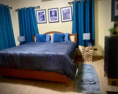 a bedroom with a bed with blue drapes at Casa Gris with Shared Pool in Ban Bo Han