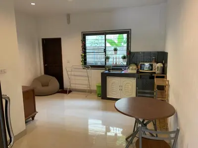 a kitchen with a table and a stool in a room at Kata House in Kata Beach