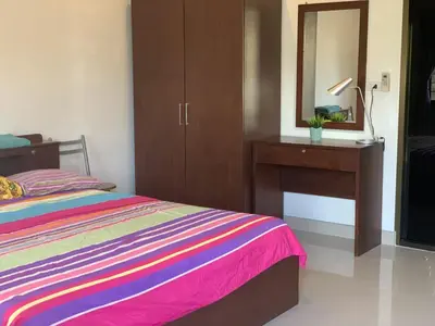 a bedroom with a bed and a dresser and a mirror at Kata House in Kata Beach