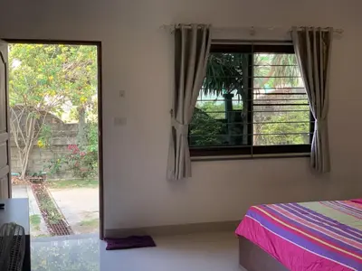 a bedroom with a window with a view of a yard at Kata House in Kata Beach