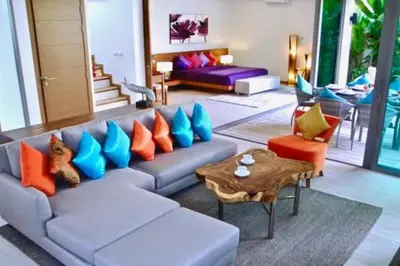 a living room with a couch with colorful pillows at Rawai Beach Pool Villa 3 bedrooms in Rawai Beach