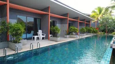 a resort with a swimming pool in front of a building at Ohophuket in Phuket Town