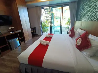 a large bed with red and white pillows on it at Ohophuket in Phuket Town