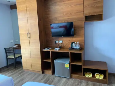 a room with a desk with a tv on a wall at Ohophuket in Phuket Town