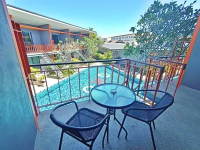 a table and two chairs on a balcony with a pool at Ohophuket in Phuket Town
