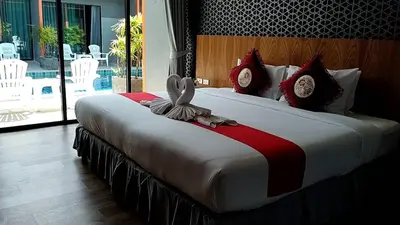 a bedroom with a large bed with a towel on it at Ohophuket in Phuket Town