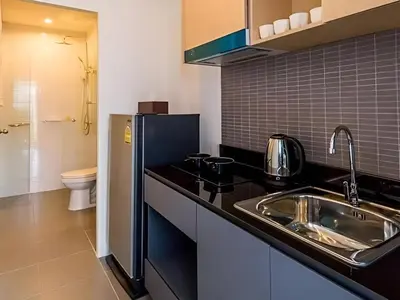 a kitchen with a sink and a refrigerator at Condo Near Bangtao Muay Thai & MMA in Ban Thalat Choeng Thale