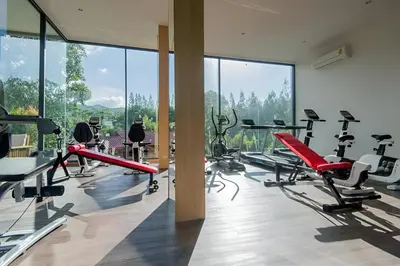 a gym with a lot of treadmills and machines at Condo Near Bangtao Muay Thai & MMA in Ban Thalat Choeng Thale