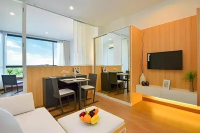 a living room with a couch and a dining room at Condo Near Bangtao Muay Thai & MMA in Ban Thalat Choeng Thale
