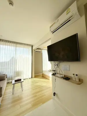 a living room with a flat screen tv on a wall at The Rocco pool view in Krabi town