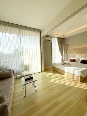 a large bedroom with a bed and a couch at The Rocco pool view in Krabi town