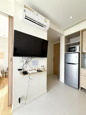 a living room with a large flat screen tv on the wall at The Rocco pool view in Krabi town