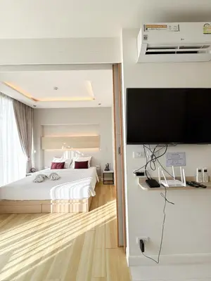 a bedroom with a bed and a flat screen tv at The Rocco pool view in Krabi town