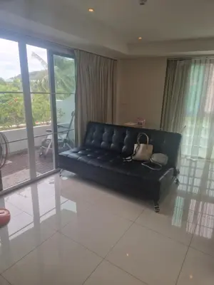 a black couch in a living room with a balcony at Condo for rent Kata Beach in Kata Beach