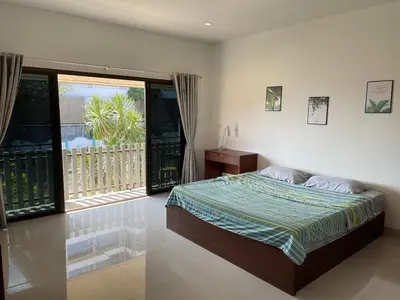 a bedroom with a bed and a balcony at Kata House 2 in Kata Beach