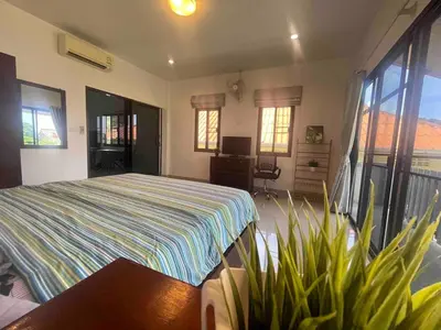 a bedroom with a bed and some plants in it at Kata House 2 in Kata Beach