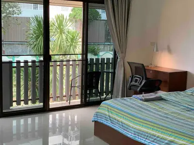 a bedroom with a bed and a balcony at Kata House 2 in Kata Beach