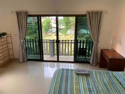 a bedroom with a bed and a balcony at Kata House 2 in Kata Beach