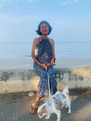 a woman standing next to a dog on a leash at Cat Home Ao Nang Landmark in Ao Nang Beach