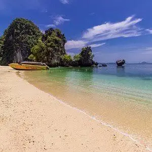 a beach with a boat in the water at Cat Home Ao Nang Landmark in Ao Nang Beach