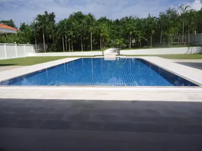 a swimming pool with blue water in a backyard at Villa Tha Maphrao in Ban Pa Khlok