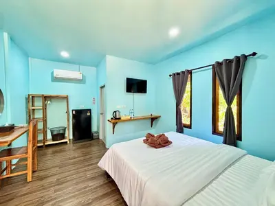 a blue bedroom with a bed and a desk at Abir Homestay Koh Yao Yai in Ban Phlu Nai