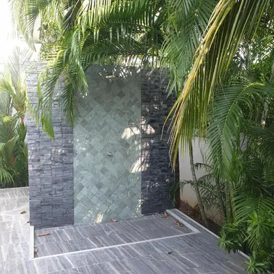 a patio with a brick wall and trees at sengjan garden krabi in Ban Khlong Son