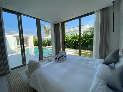 a bedroom with a large white bed and a pool at 3bdr New Modern Pool Villa Bangtao ASH-05 in Ban Phru Champa