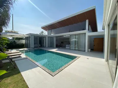 a swimming pool in the backyard of a house at 3bdr New Modern Pool Villa Bangtao ASH-05 in Ban Phru Champa