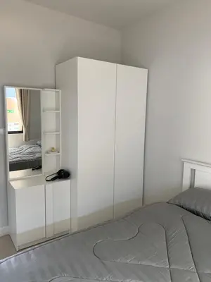 a white bedroom with a bed and a mirror at 9169SiriplaceAirport in Ban Muang Mai (1)