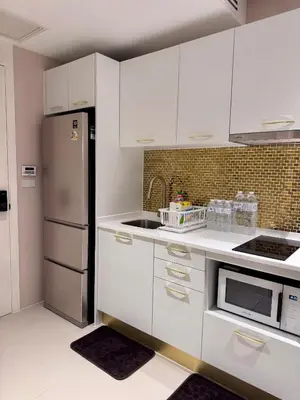 a kitchen with white cabinets and a stainless steel refrigerator at Luxury 2 Person Apartment in Heart of Phuket in Ban Ket Ho