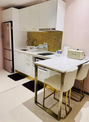 a kitchen with white cabinets and a table and chairs at Luxury 2 Person Apartment in Heart of Phuket in Ban Ket Ho
