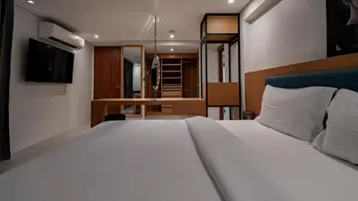 a bedroom with a large white bed and a television at Luxury Modern Loft Villa Riverhouse in Laguna Phuket